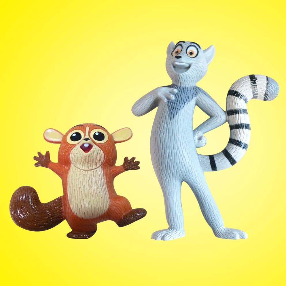 Two Madagascar lemur character figures, one small and brown and the other tall and grey with a striped tail, displayed against a bright yellow background.