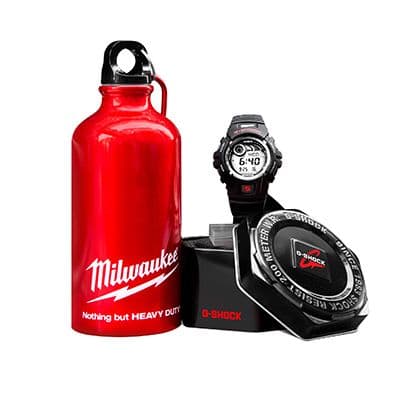 Red Milwaukee metal flask displayed beside a black G-Shock wristwatch and matching branded presentation tin.