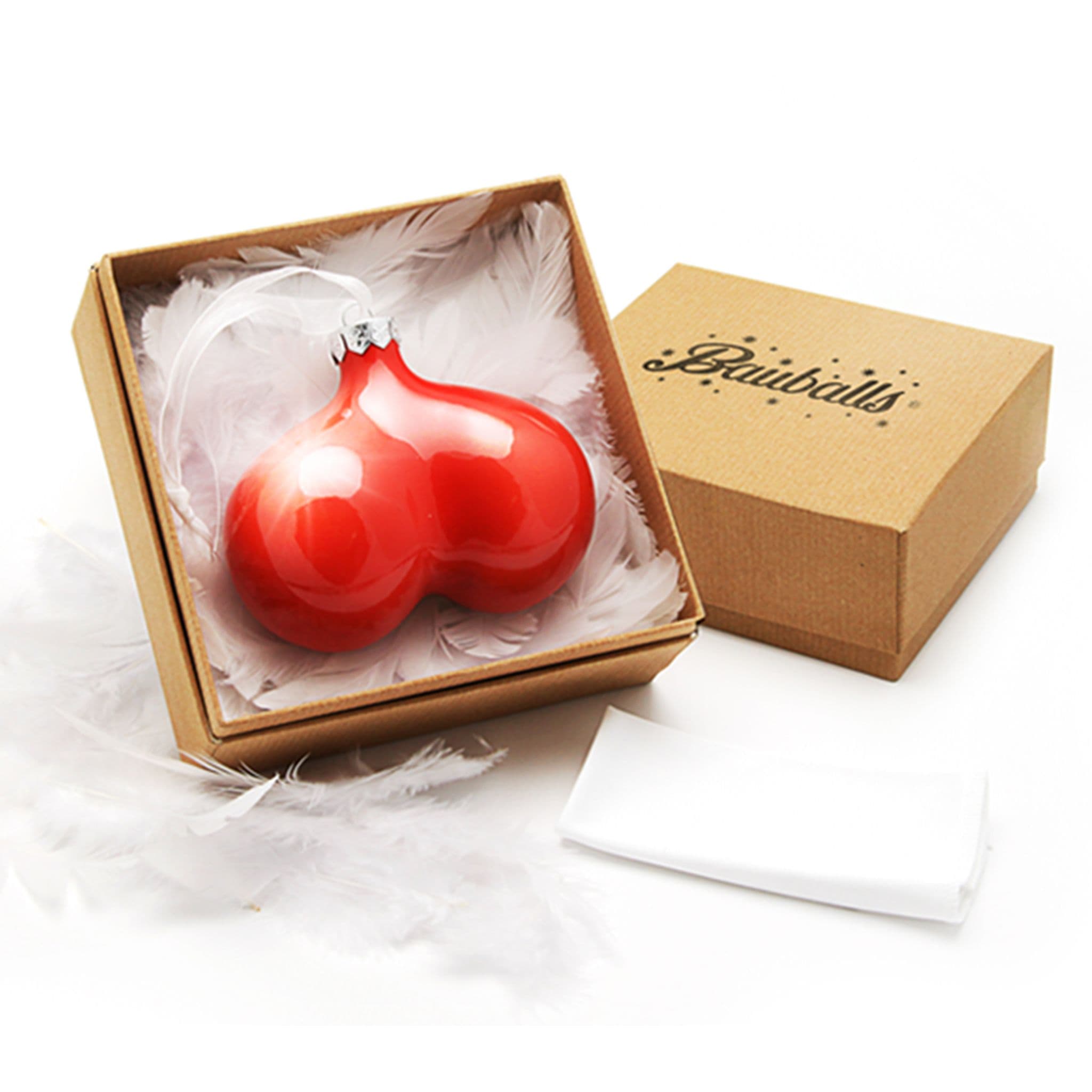 Glossy red Bauballs novelty Christmas decoration presented among white feathers in an open branded gift box.
