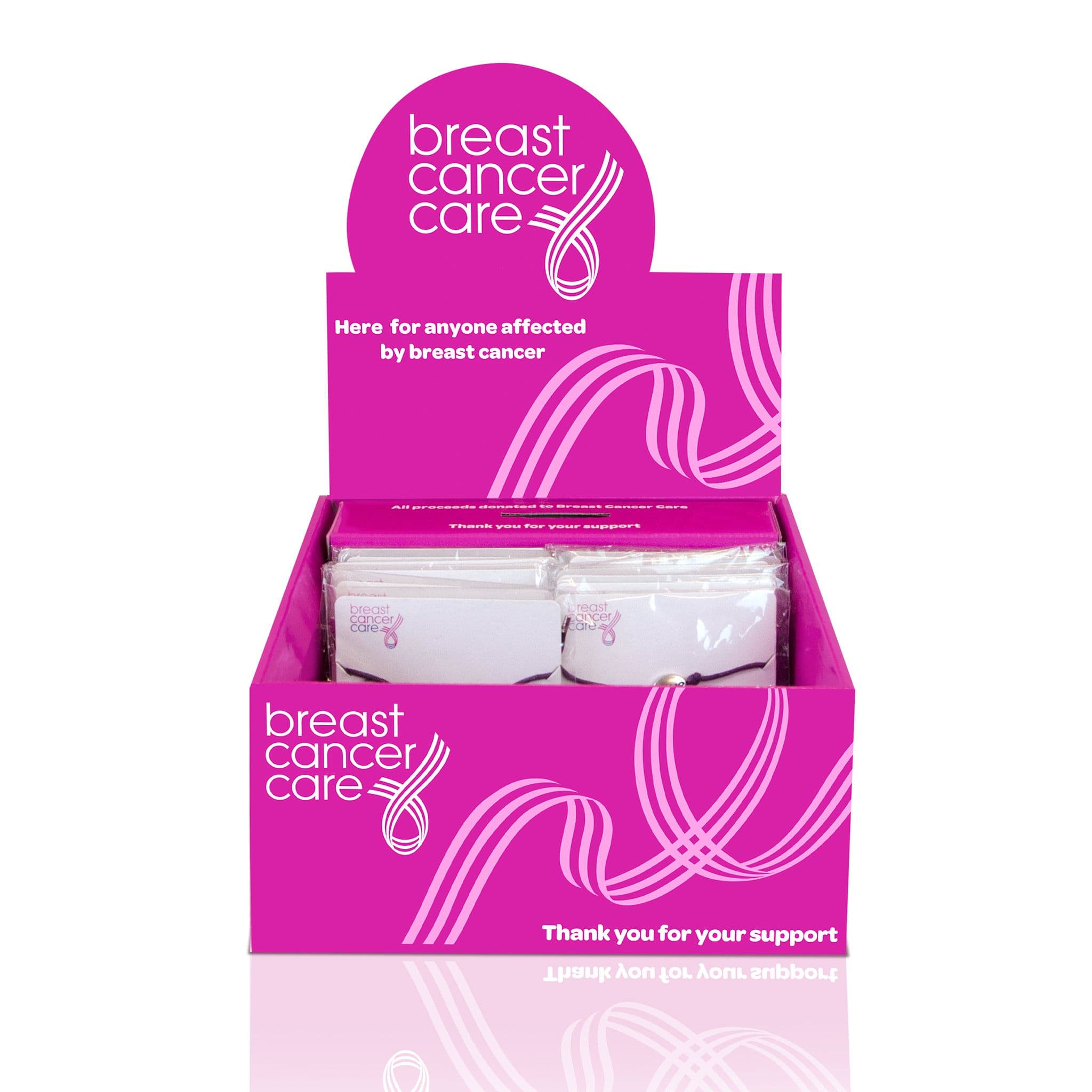 Bright pink Breast Cancer Care counter display box holding packaged fundraising items, with charity branding and the message “Thank you for your support.”